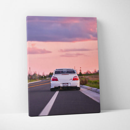 Subaru WRX STI on road at sunset canvas wall art with pink and purple sky.