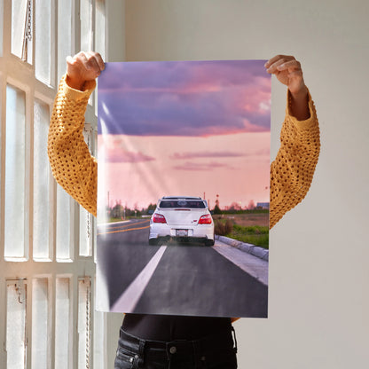 Subaru WRX STI driving on highway at sunset poster wall art with vibrant purple and pink sky.