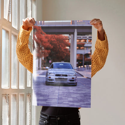 Nissan GTR R34 Skyline car driving on urban street poster wall art in autumn colors.
