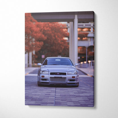Vertical canvas art featuring a silver Nissan GTR R34 Skyline parked on a paved street with autumn foliage, wall art print.