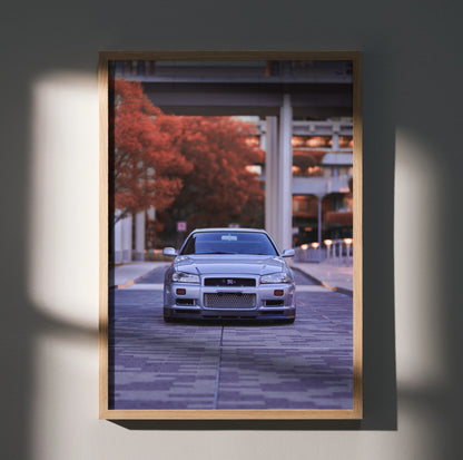 Nissan R34 GTR Skyline poster wall art with urban background and autumn red trees.