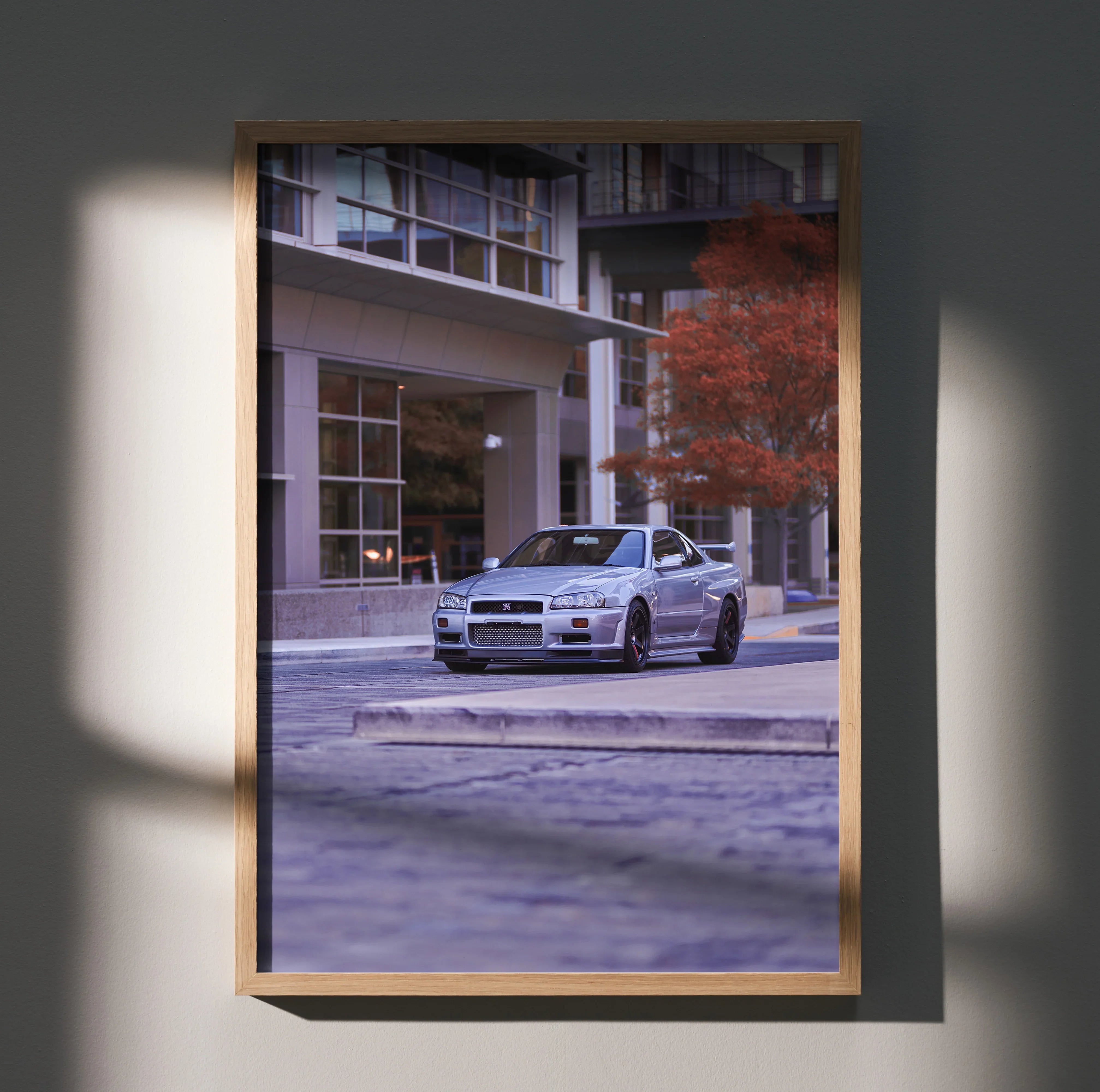 Nissan GTR R34 Skyline parked on city street vintage automotive poster wall art in wooden frame.