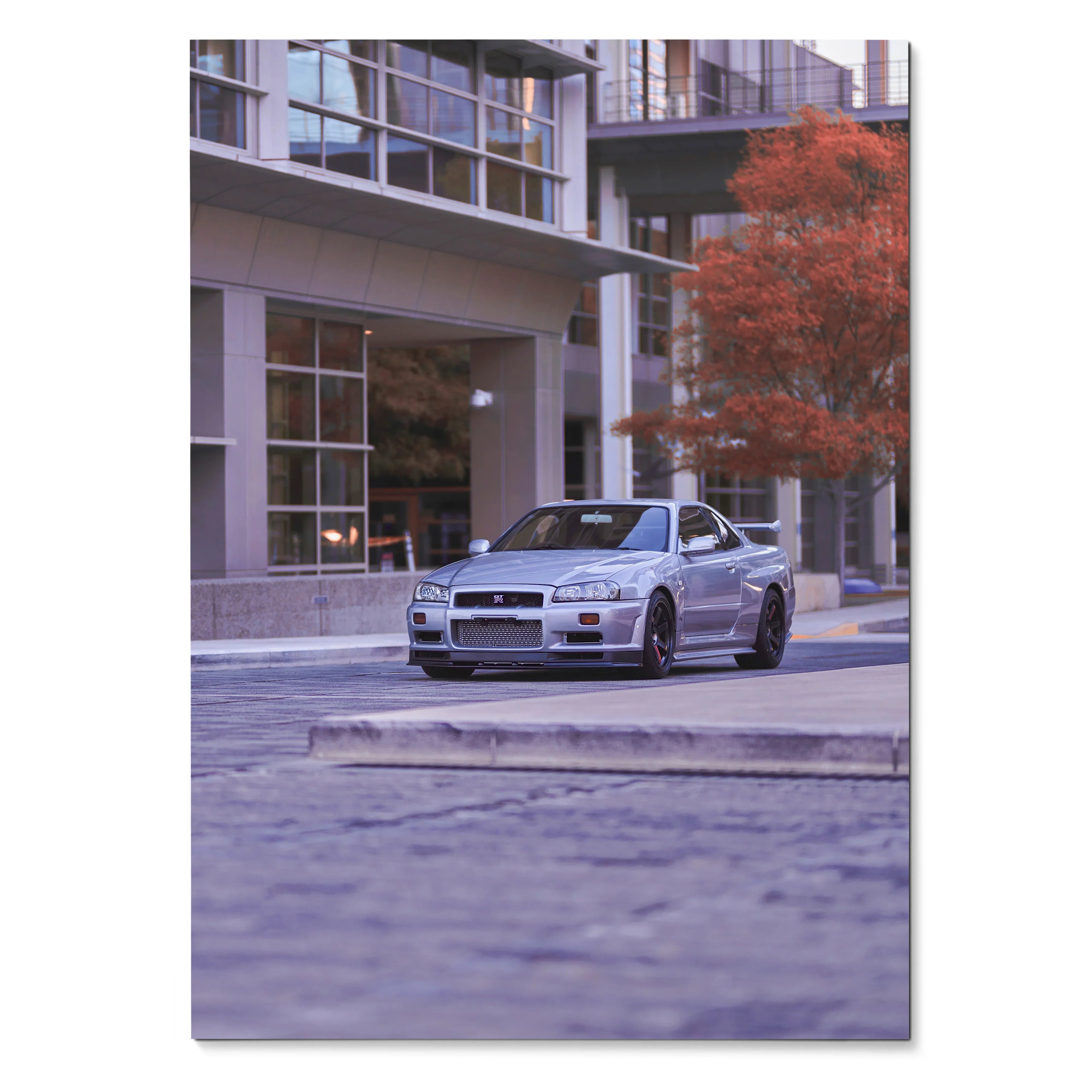 Nissan R34 GTR parked on urban street with modern buildings and autumn tree poster wall art.