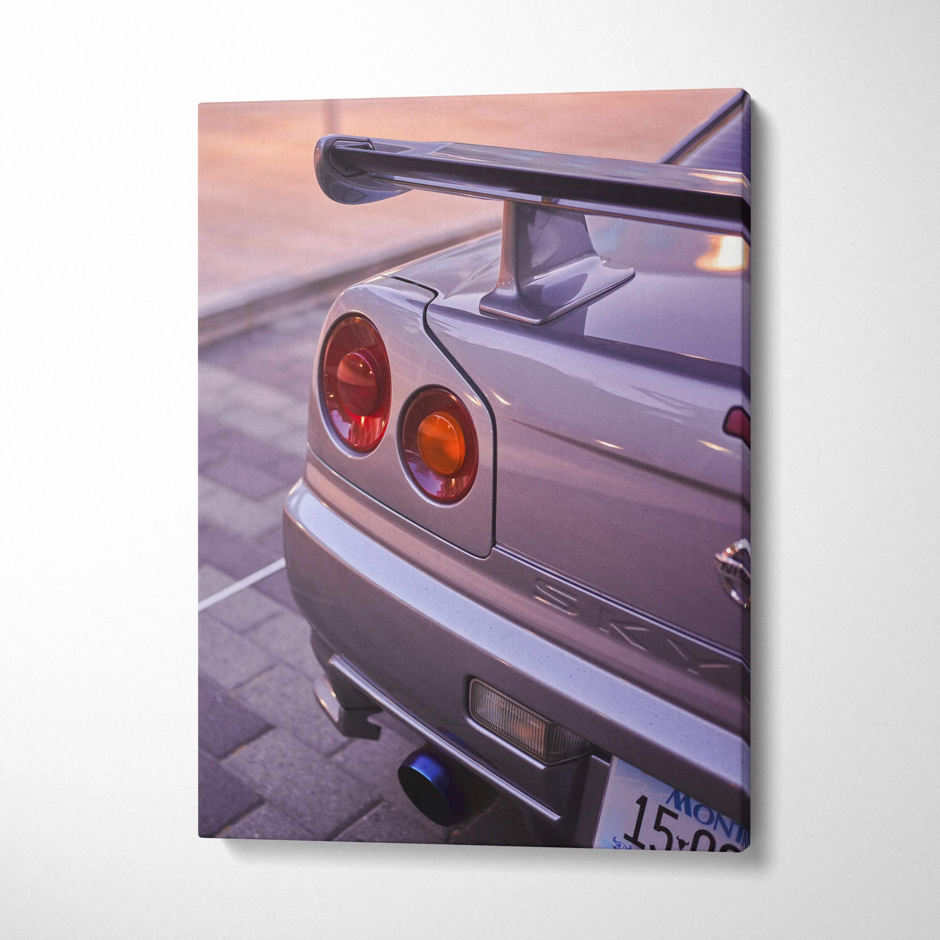Vertical canvas wall art featuring a close-up of a silver Nissan GTR R34 Skyline tail light and spoiler at sunset.