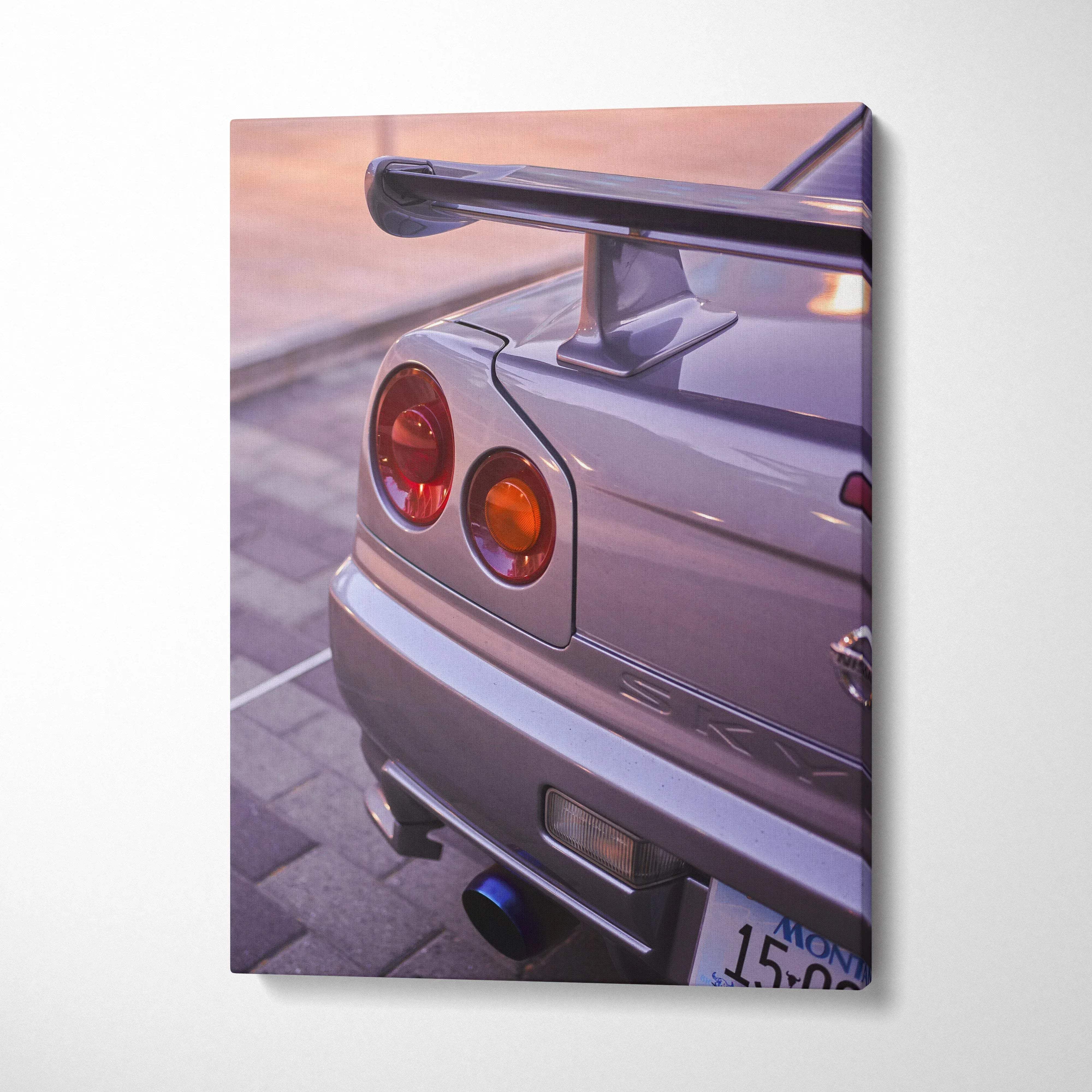 Vertical canvas wall art featuring a close-up of a silver Nissan GTR R34 Skyline tail light and spoiler at sunset.