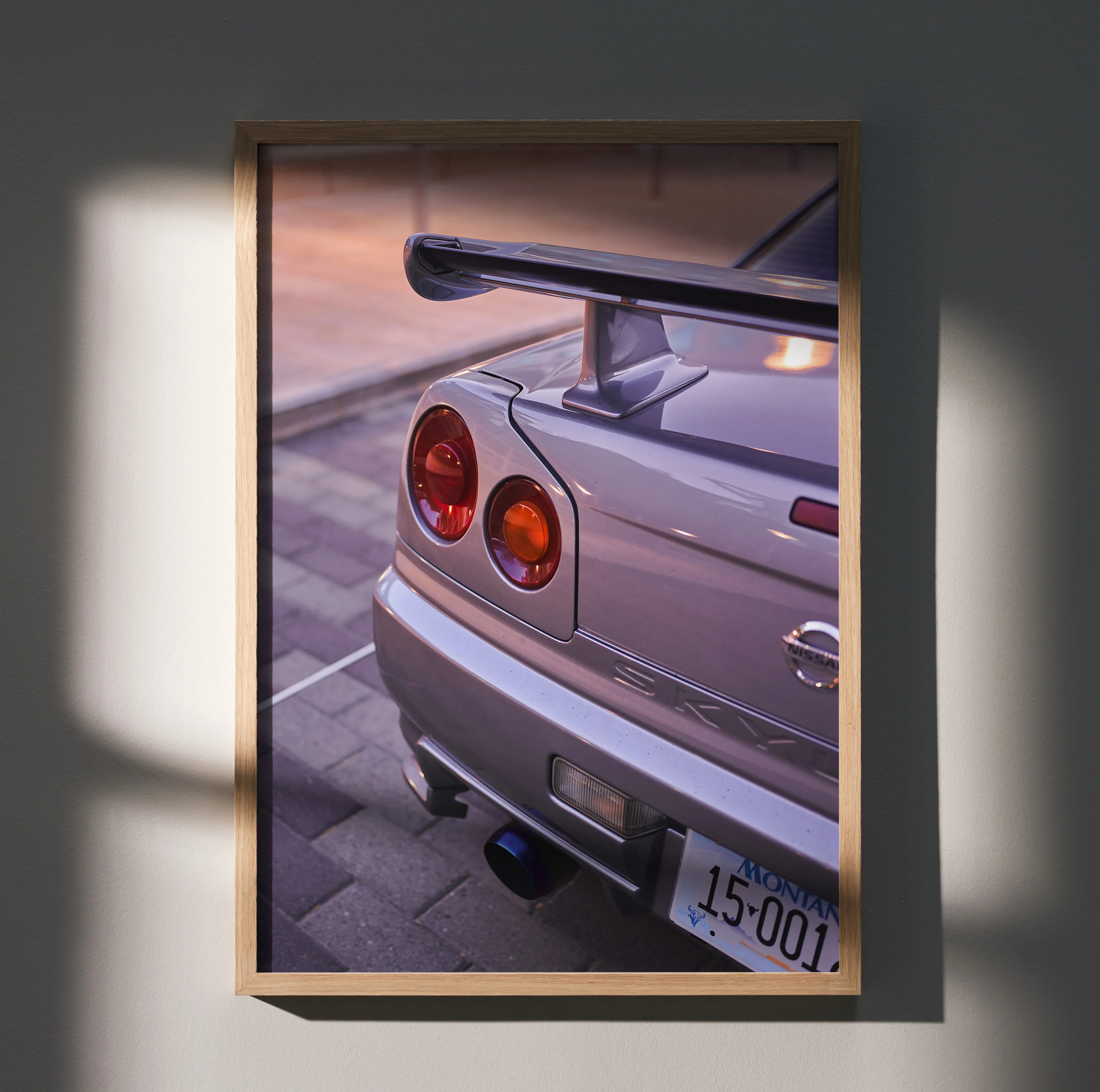 Nissan GTR R34 Skyline rear detail poster wall art in wooden frame with sunset lighting.