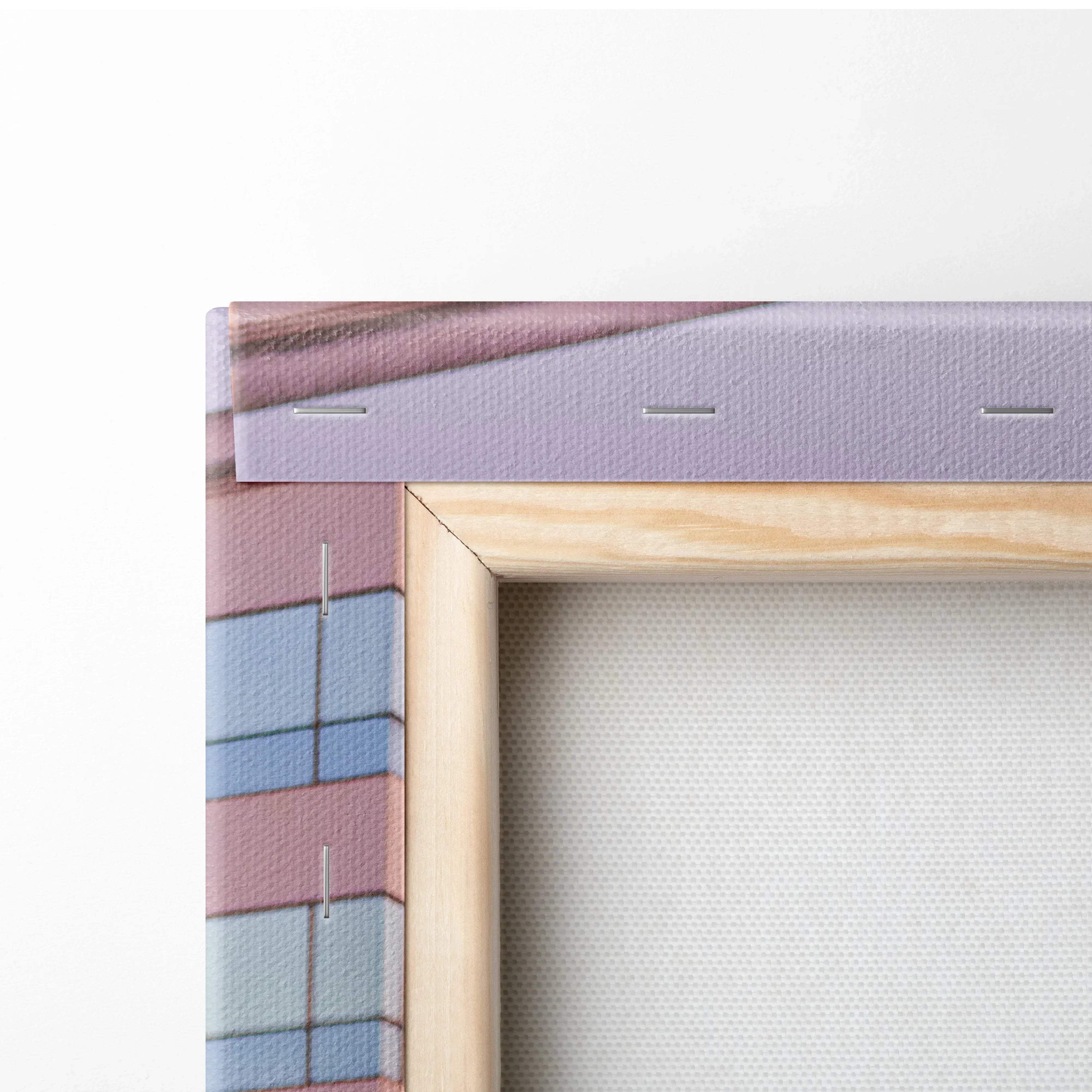 Close-up of gallery-wrapped canvas art with wooden frame and staple-secured edge for wall art display.