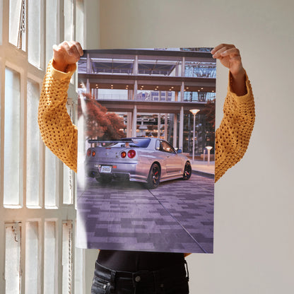 Nissan R34 GTR Skyline poster showcasing silver sports car in urban setting, stylish wall art.