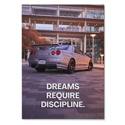 Nissan GT-R R34 Skyline parked at night with inspiring text "Dreams Require Discipline" poster wall art.