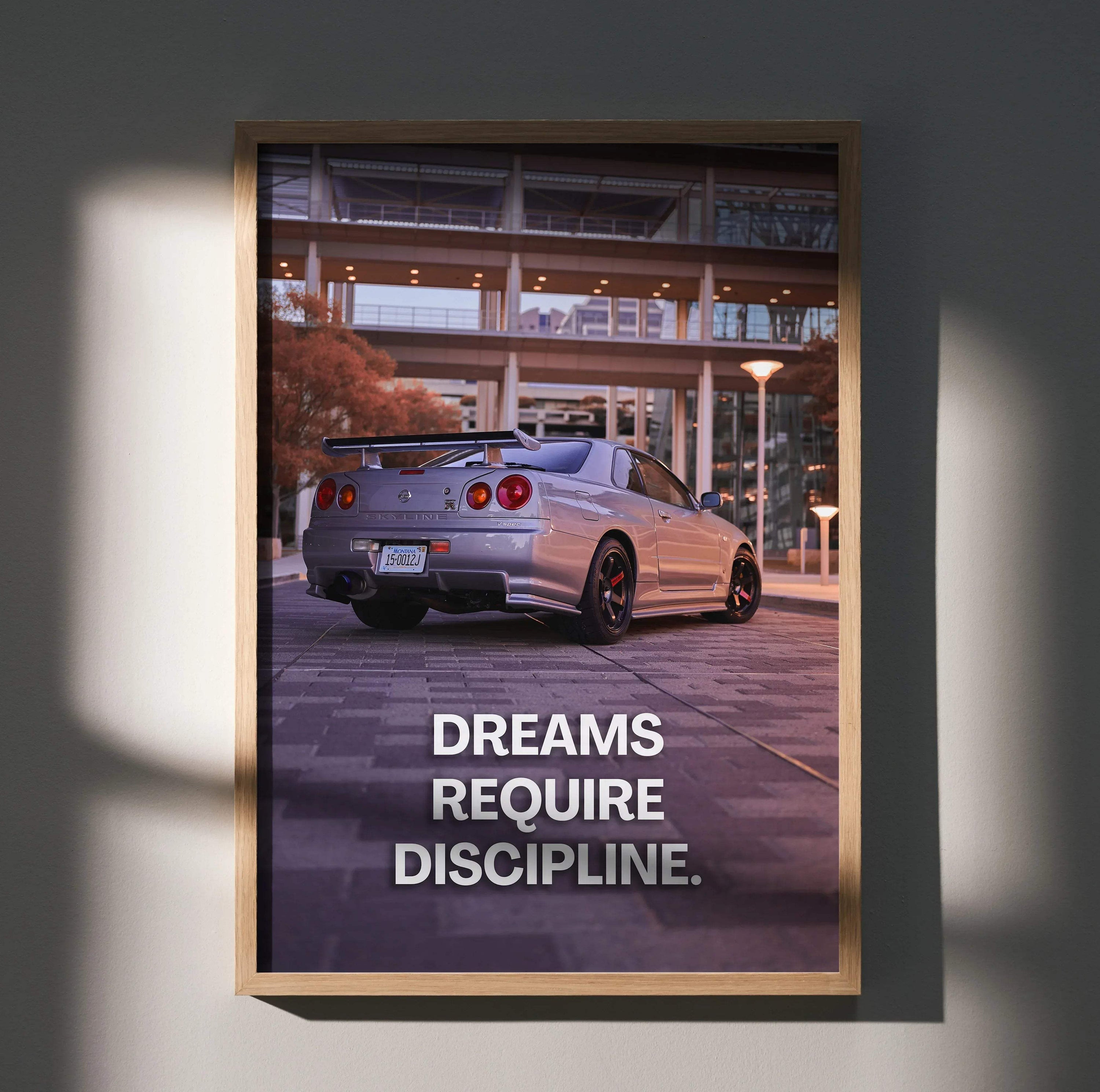 Motivational poster wall art featuring a silver Nissan GT-R R34 Skyline with the text "Dreams Require Discipline.".