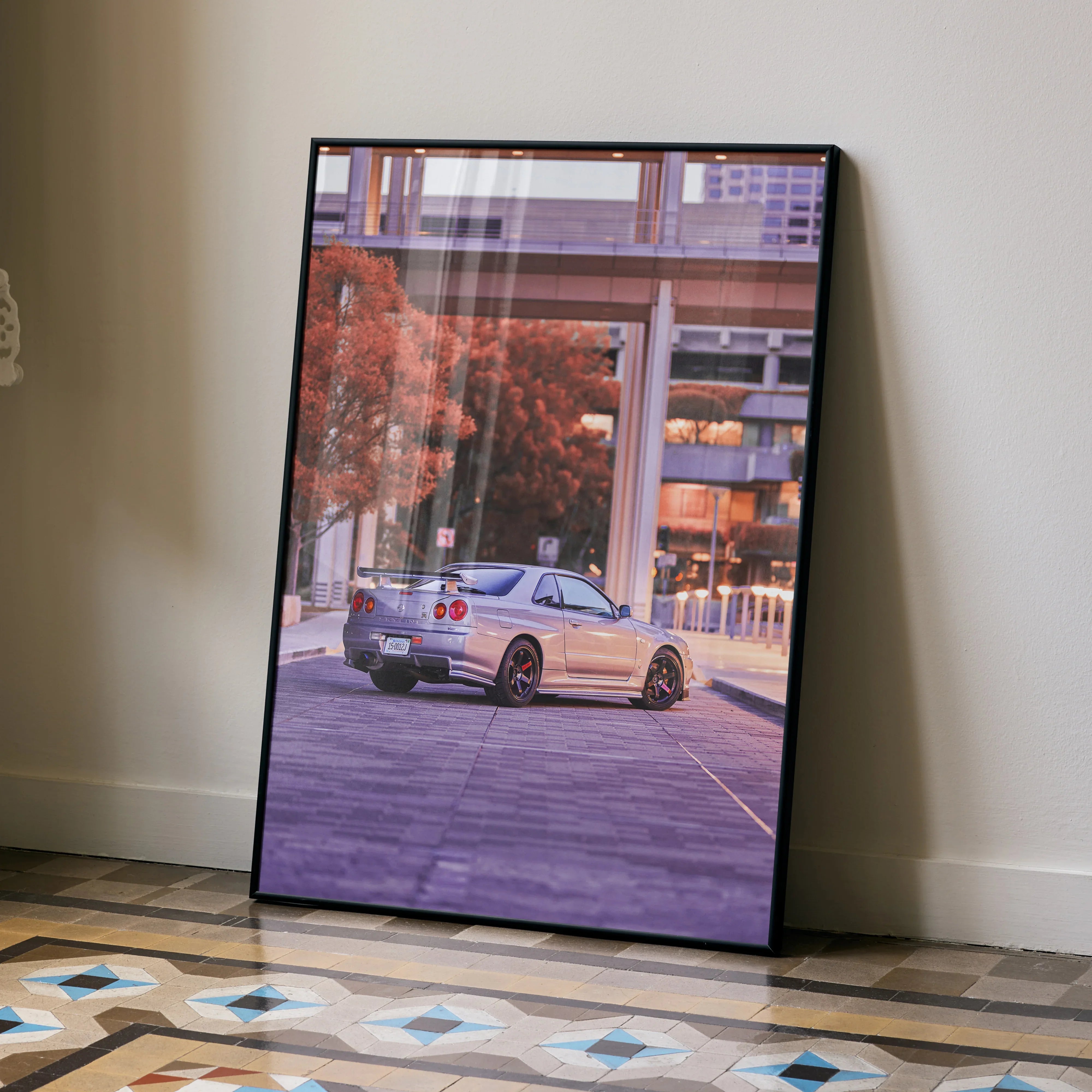 Nissan GTR R34 Skyline poster wall art featuring silver car on urban street with autumn trees and modern buildings.