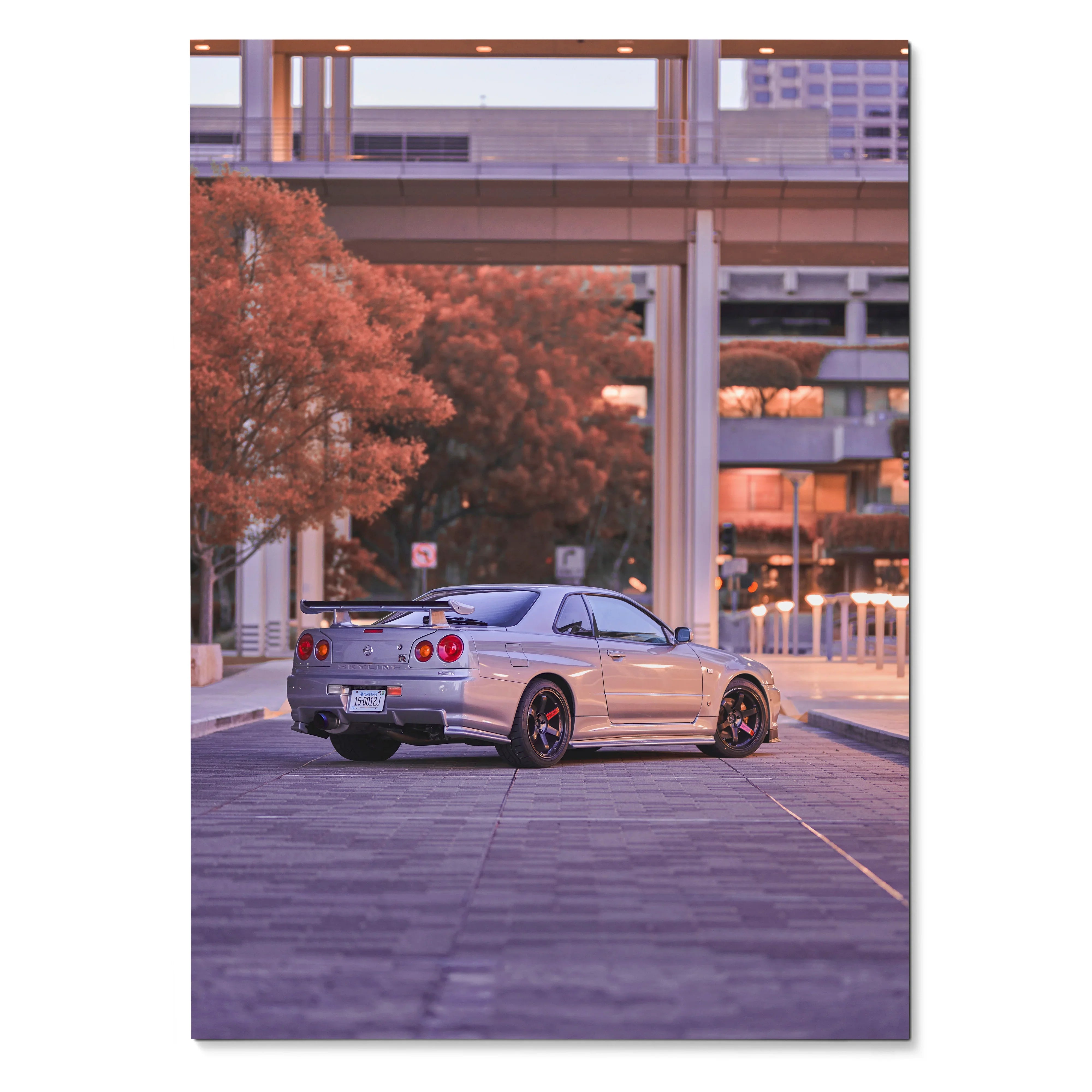Nissan R34 GTR parked on urban road at sunset poster wall art with warm city tones.