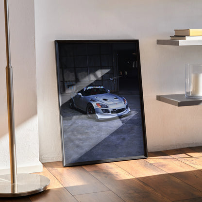 Honda S2000 poster wall art showing a sleek silver sports car in a shadowed garage setting.