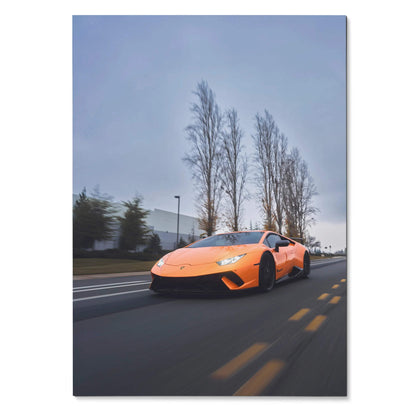 Orange Lamborghini Huracan speeding on road under tall trees wall art poster.
