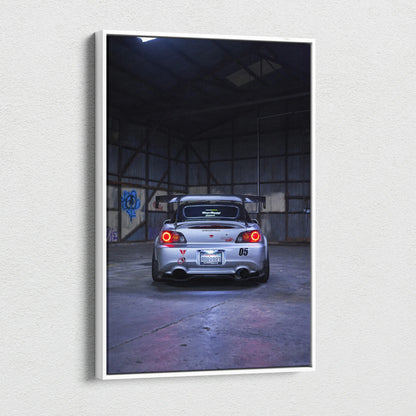 Vertical canvas wall art featuring a rear view of a silver Honda S2000 in a dimly lit industrial space.