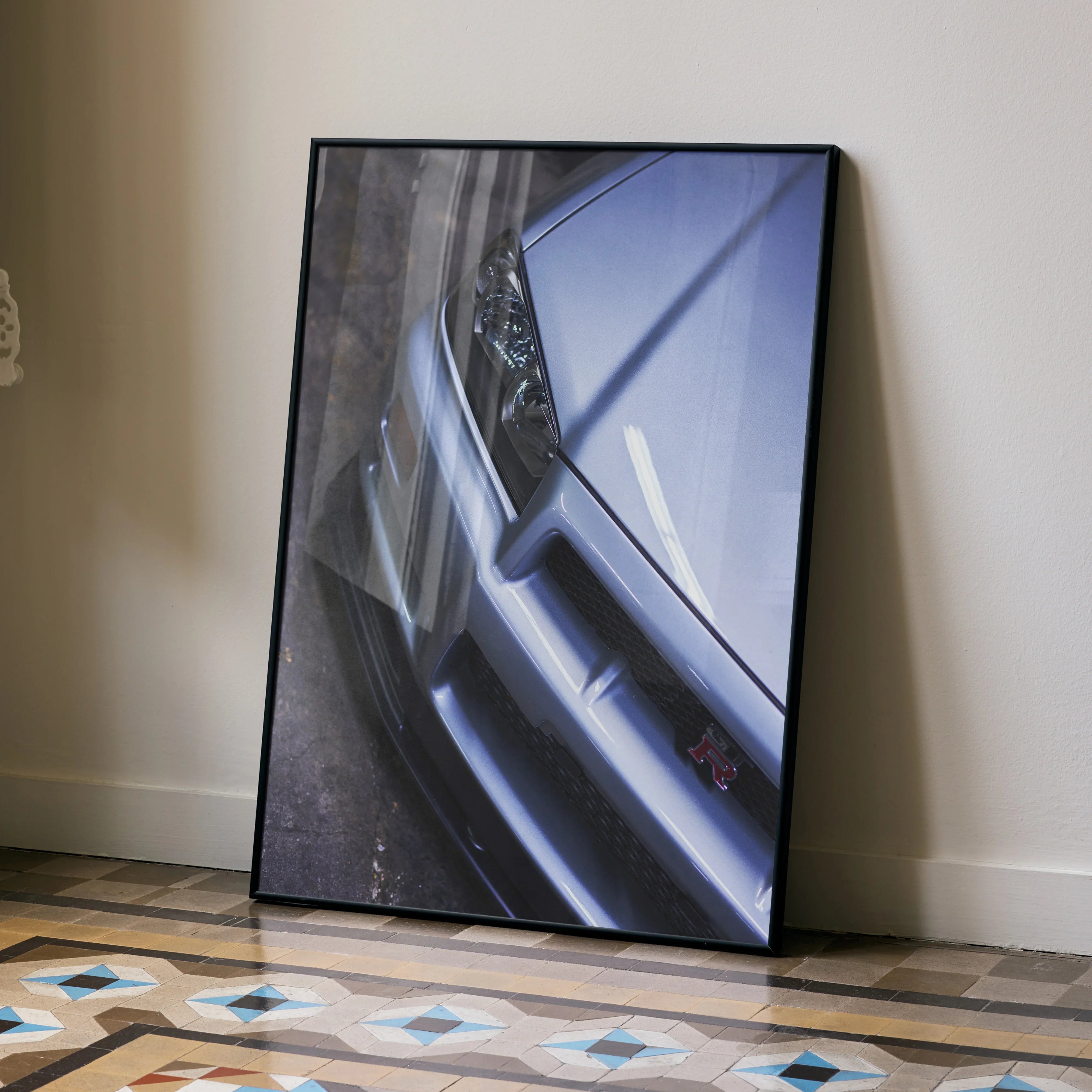 Nissan R34 GTR Skyline close-up poster leaning against wall, sleek silver car detail wall art.
