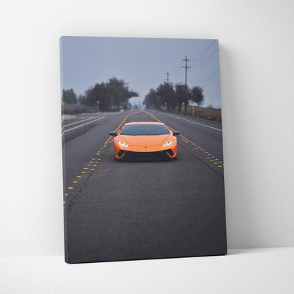 Lamborghini Huracan orange sports car on road canvas wall art with moody sky backdrop.