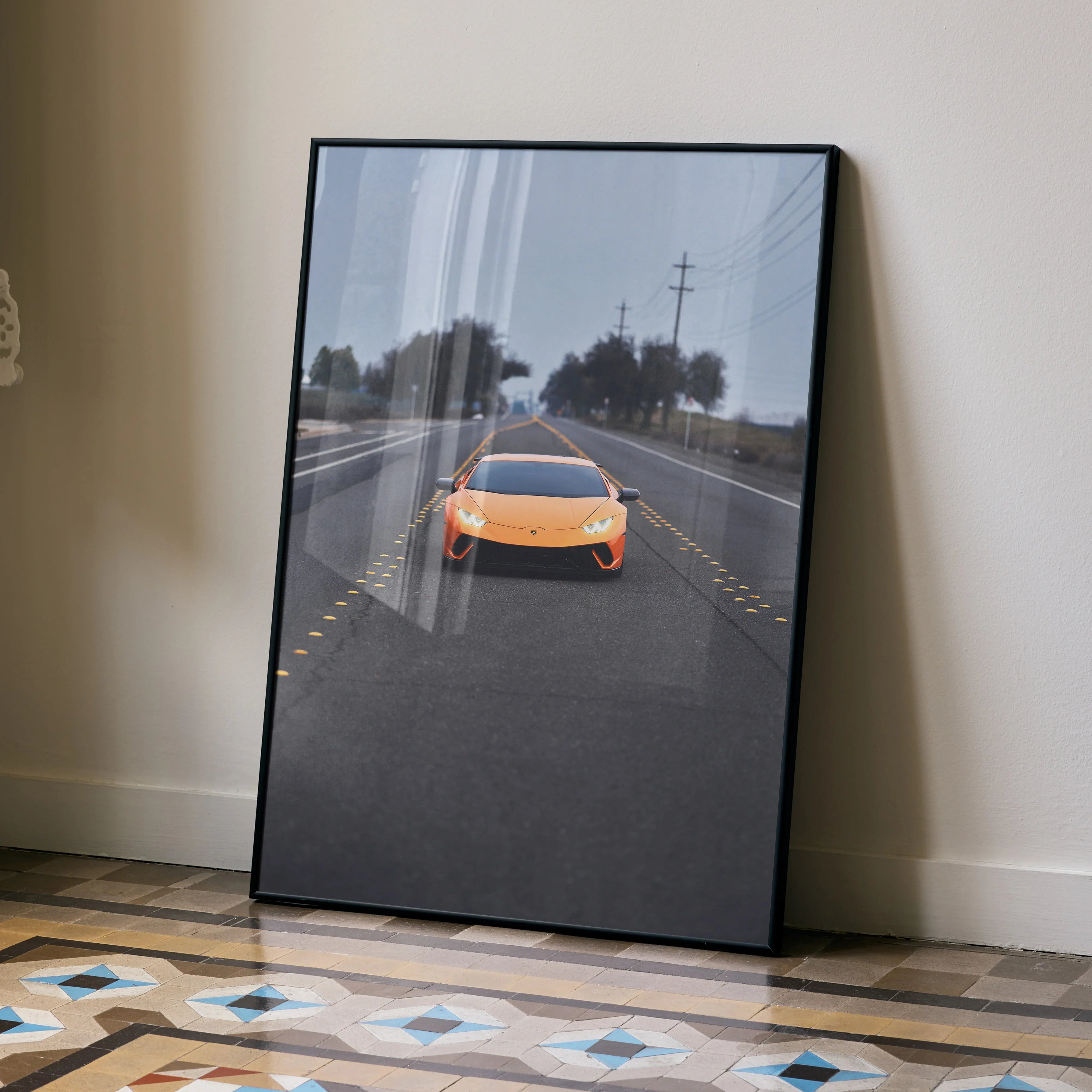 Lamborghini Huracan orange sports car poster leaning against beige wall luxury automotive wall art.