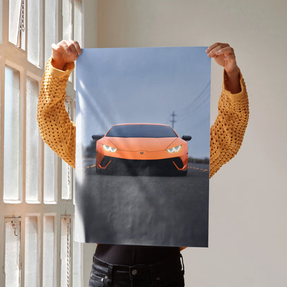 Lamborghini Huracan orange sports car poster held indoors, modern wall art with sleek automotive design.