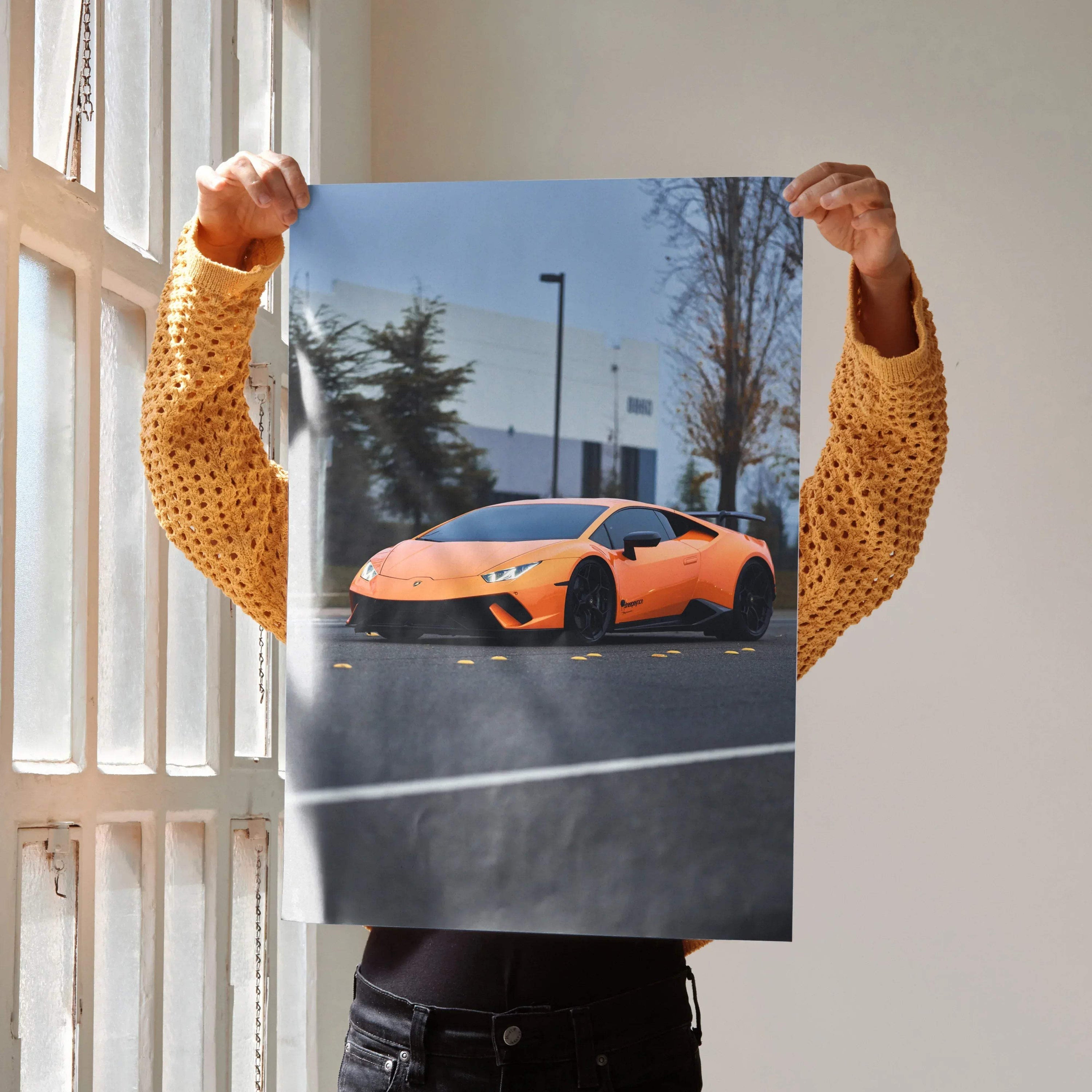 Orange Lamborghini Huracan poster showcasing sleek sports car in urban setting, glossy wall art.