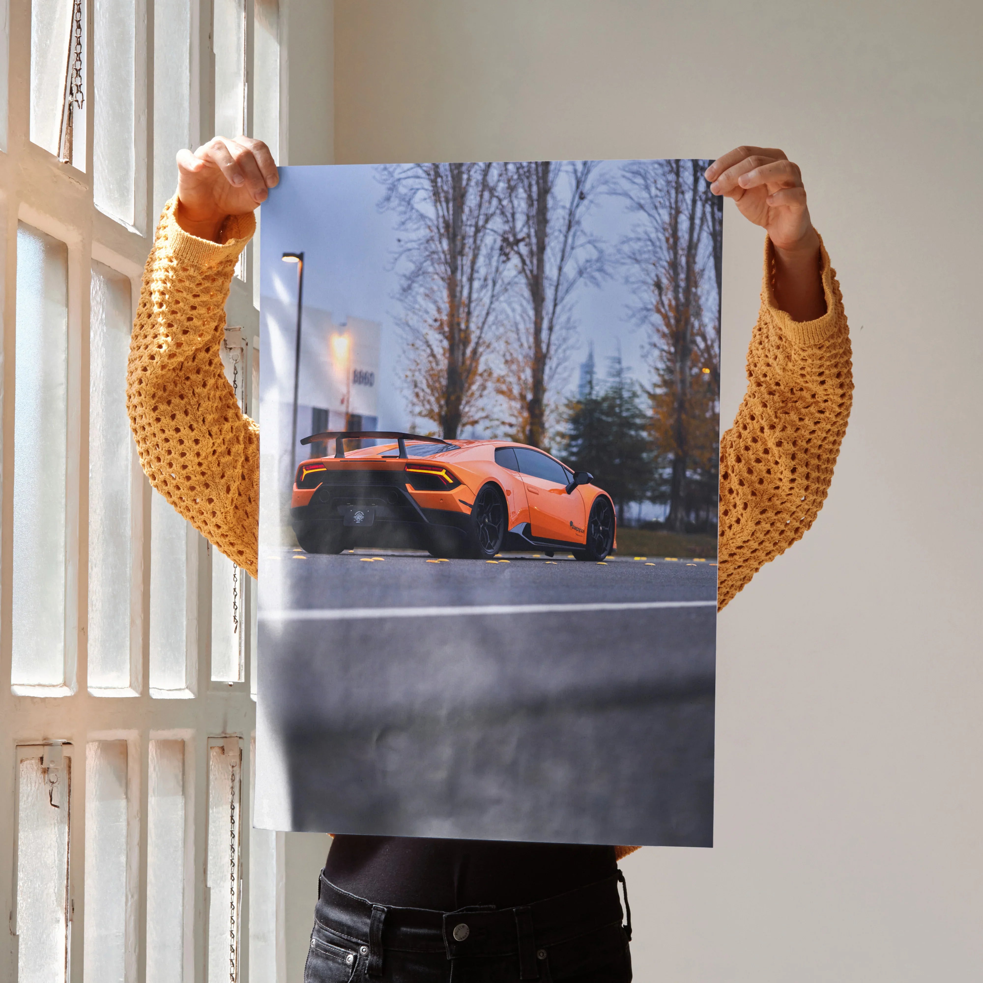 Orange Lamborghini Huracan poster with tall trees background, modern wall art decoration.