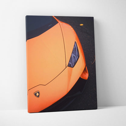 Vertical canvas art showing close-up of an orange Lamborghini Huracan front on black asphalt wall art.
