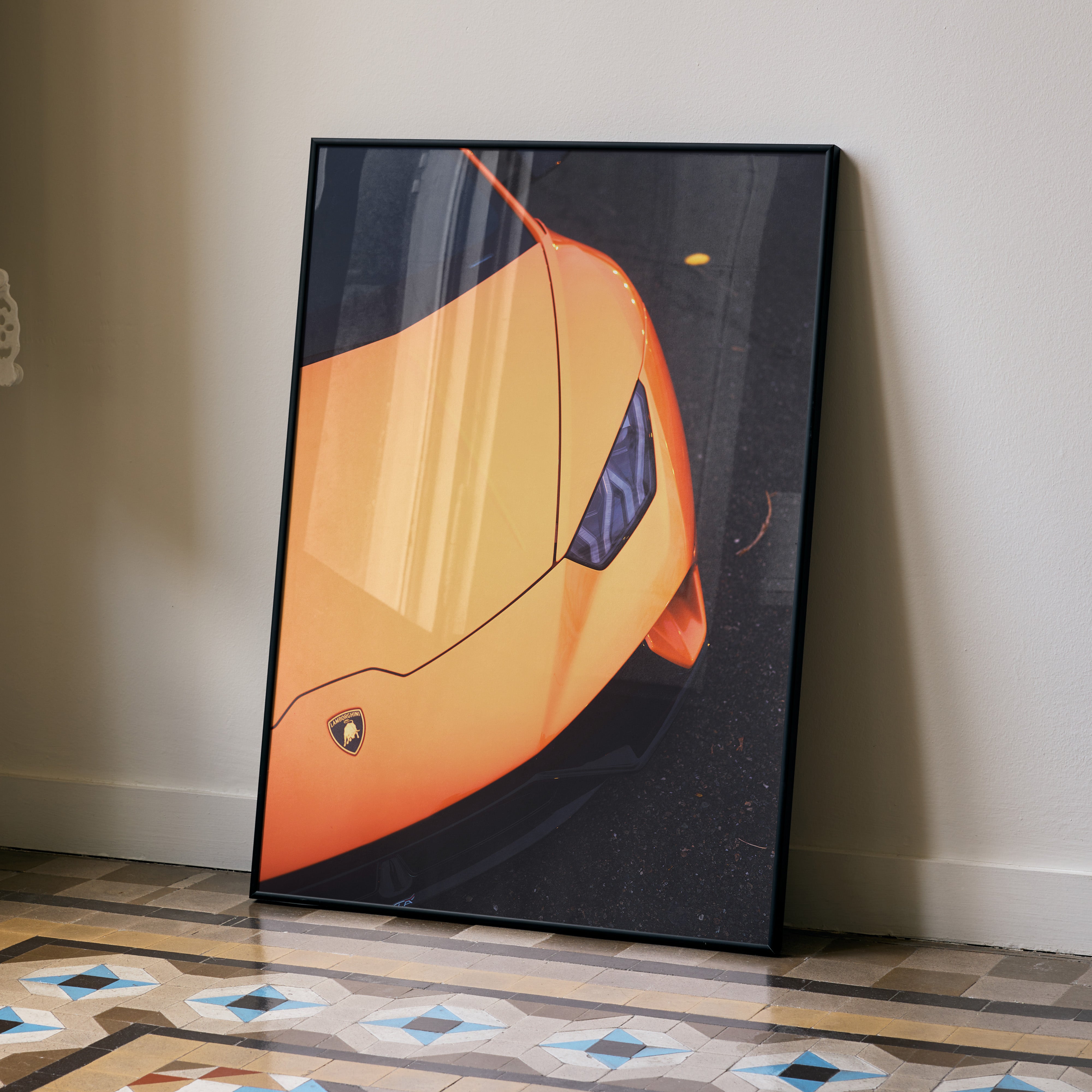 Orange Lamborghini Huracan close-up poster leaning against beige wall, premium wall art.