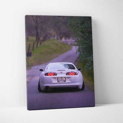 Toyota Supra MK4 rear view on winding road canvas wall art with vibrant colors.