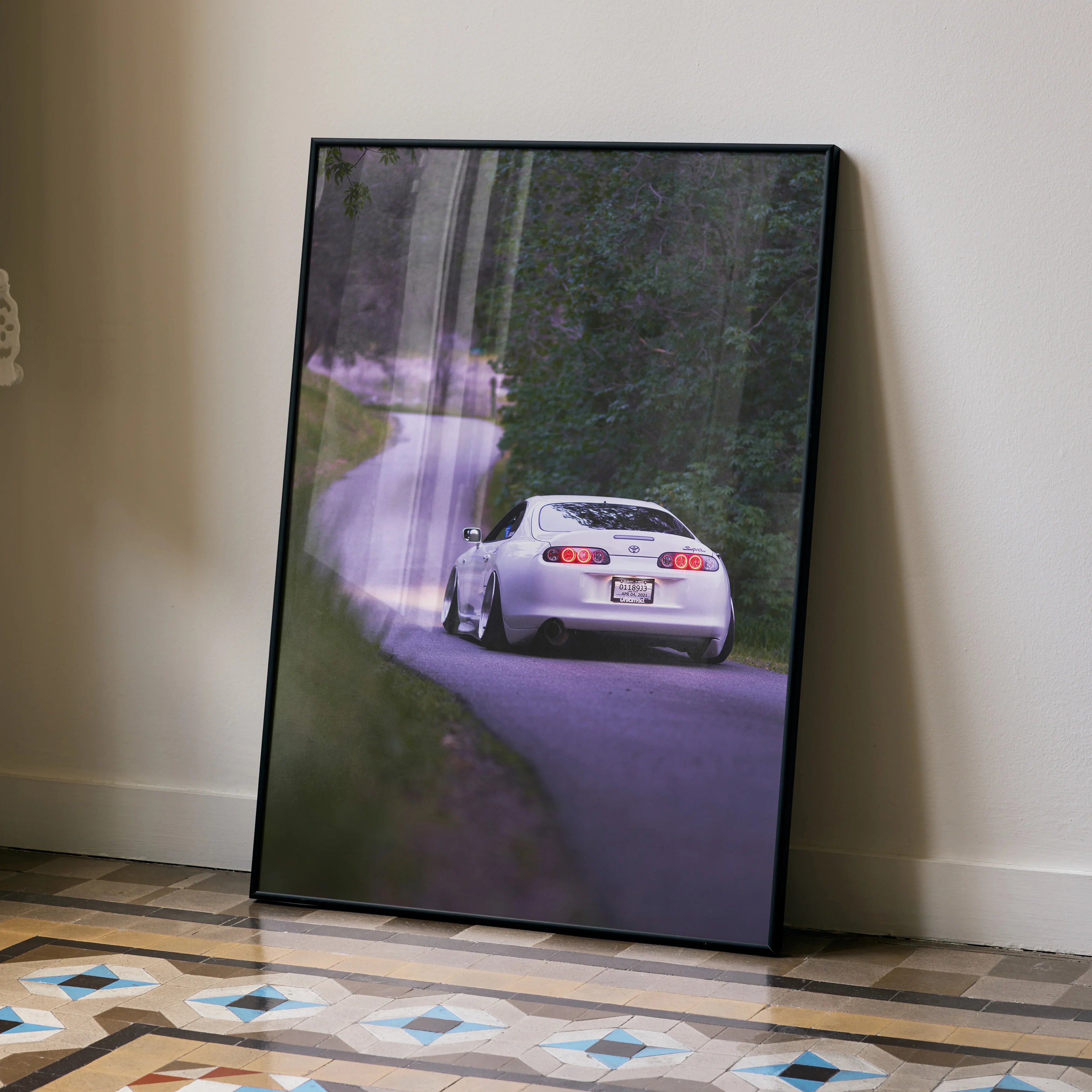 Toyota Supra MK4 poster showing rear view of white sports car on forest road, framed wall art.