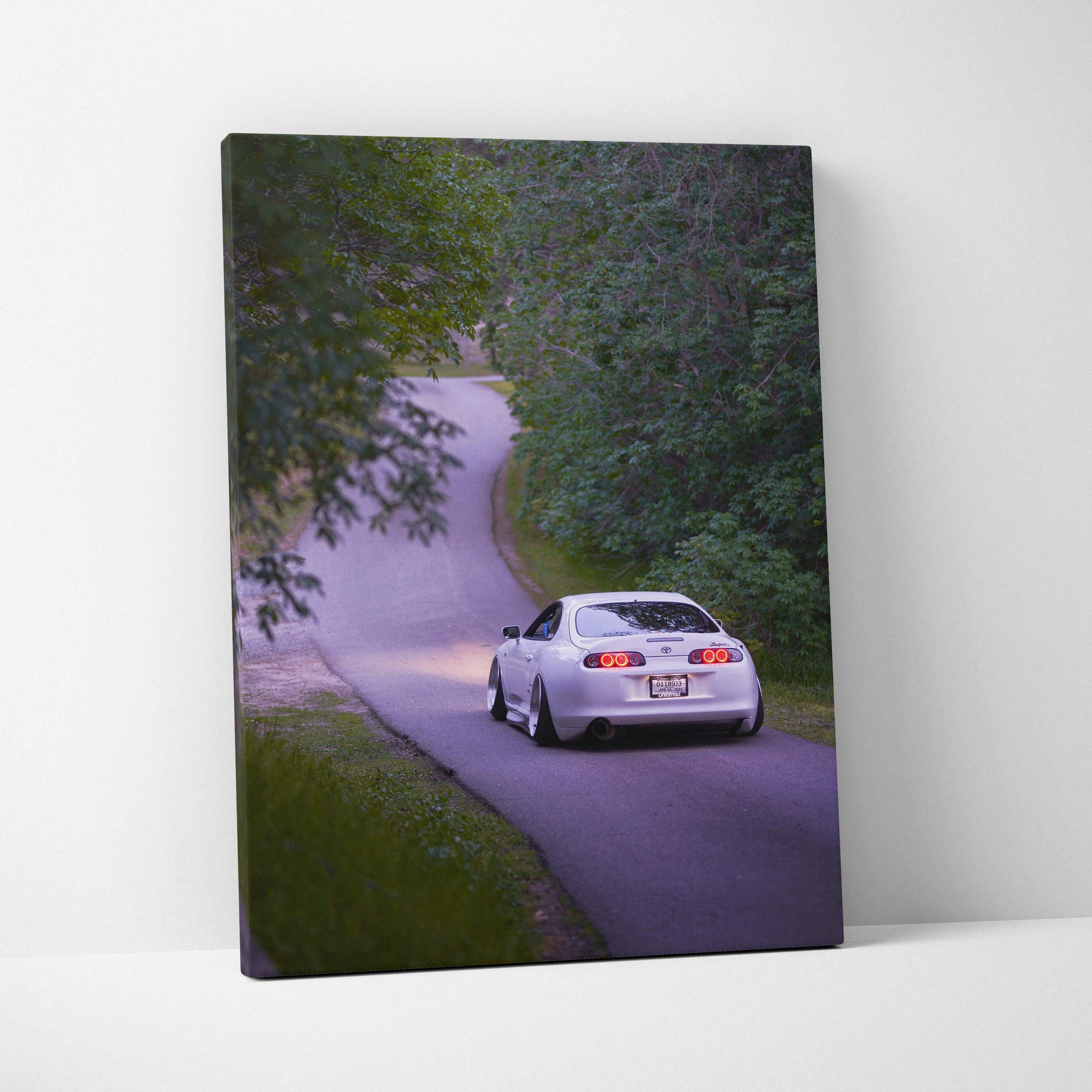 Toyota Supra MK4 driving on forest road canvas wall art in vertical layout.