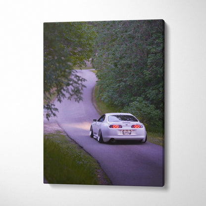Toyota Supra MK4 driving on curvy road surrounded by trees vertical canvas wall art.