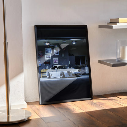 Toyota Supra MK4 poster wall art featuring a white iconic car in a dark showroom setting.