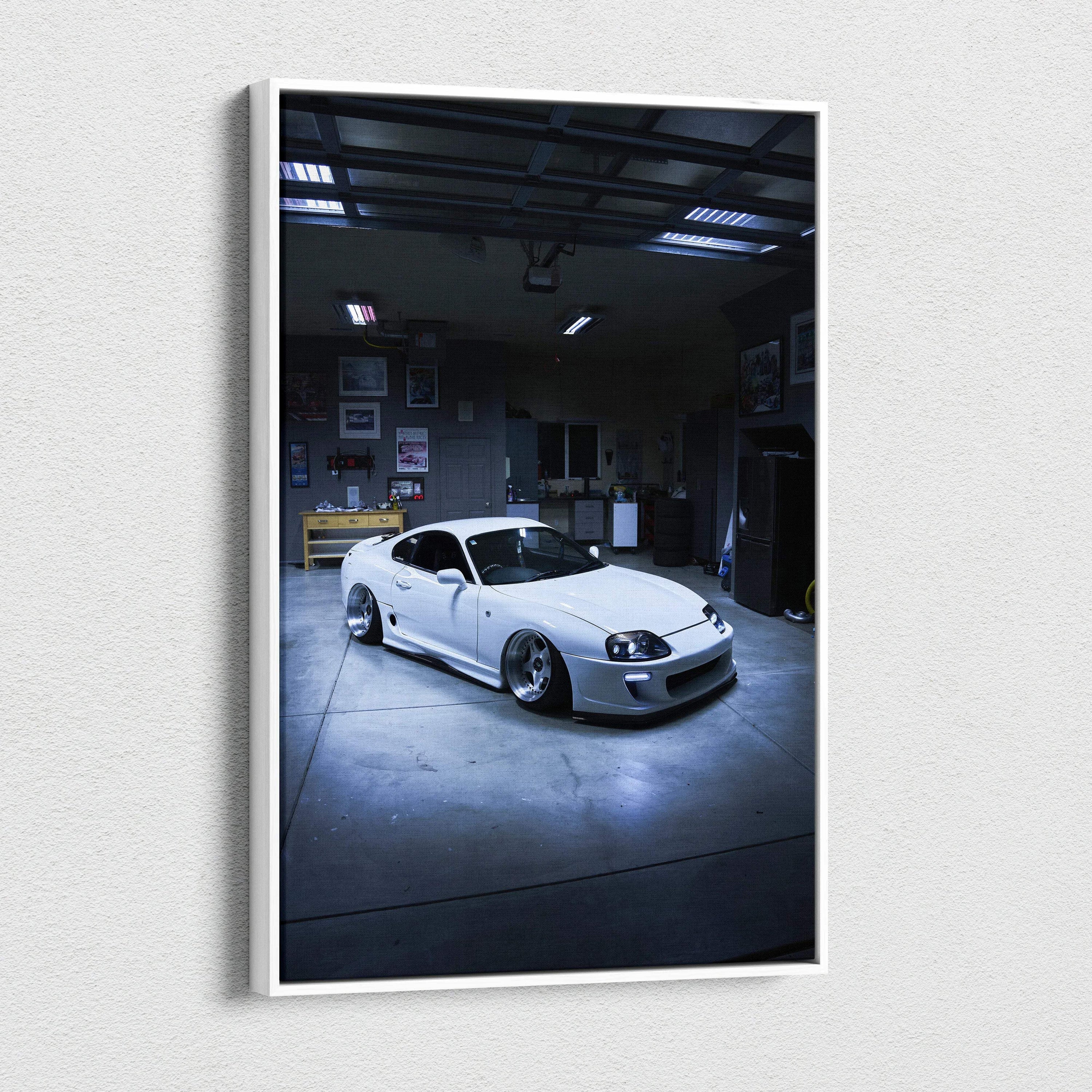 Vertical canvas wall art featuring a white Toyota Supra MK4 in a dimly lit garage setting.