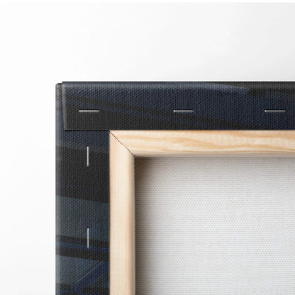 Close-up of wooden frame and black stapled edge on vertical canvas wall art.