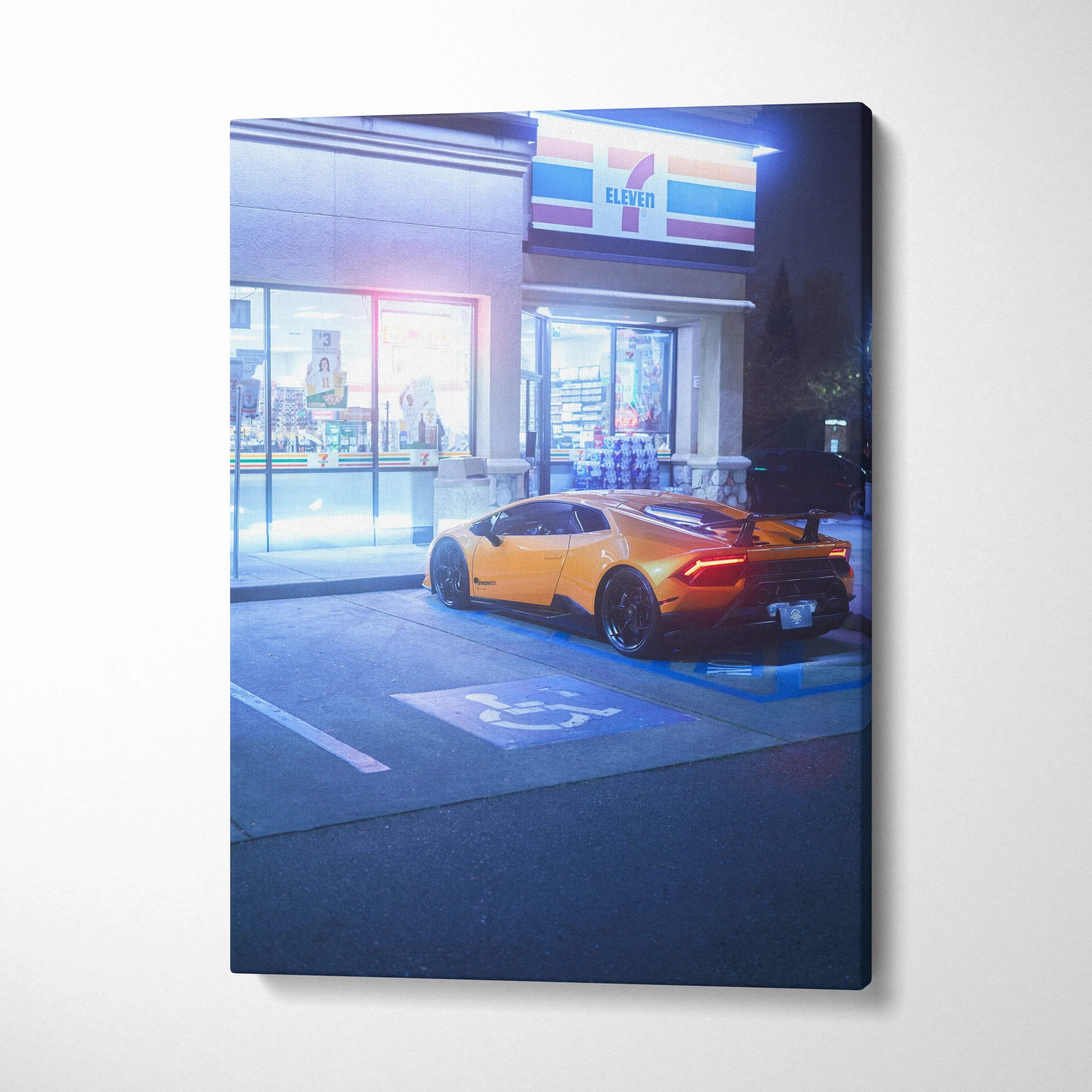 Canvas wall art featuring a yellow Lamborghini Huracan parked outside a store at night.