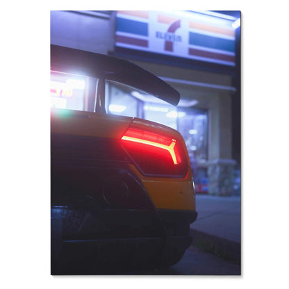 Lamborghini Huracan rear brake light glowing red at night poster wall art with blurred urban background.