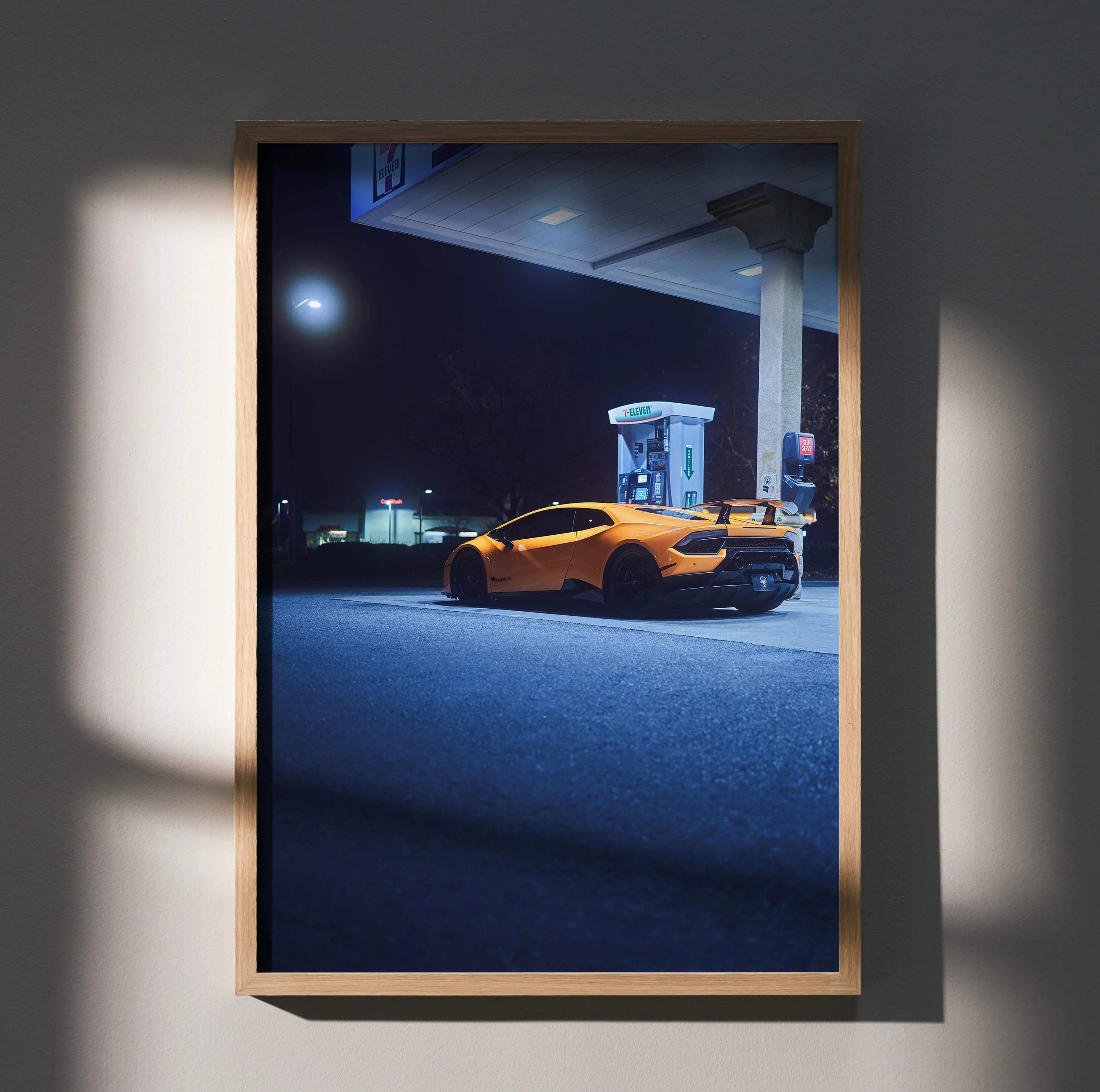 Lamborghini Huracan poster showing orange sports car at gas station under moonlight wall art.