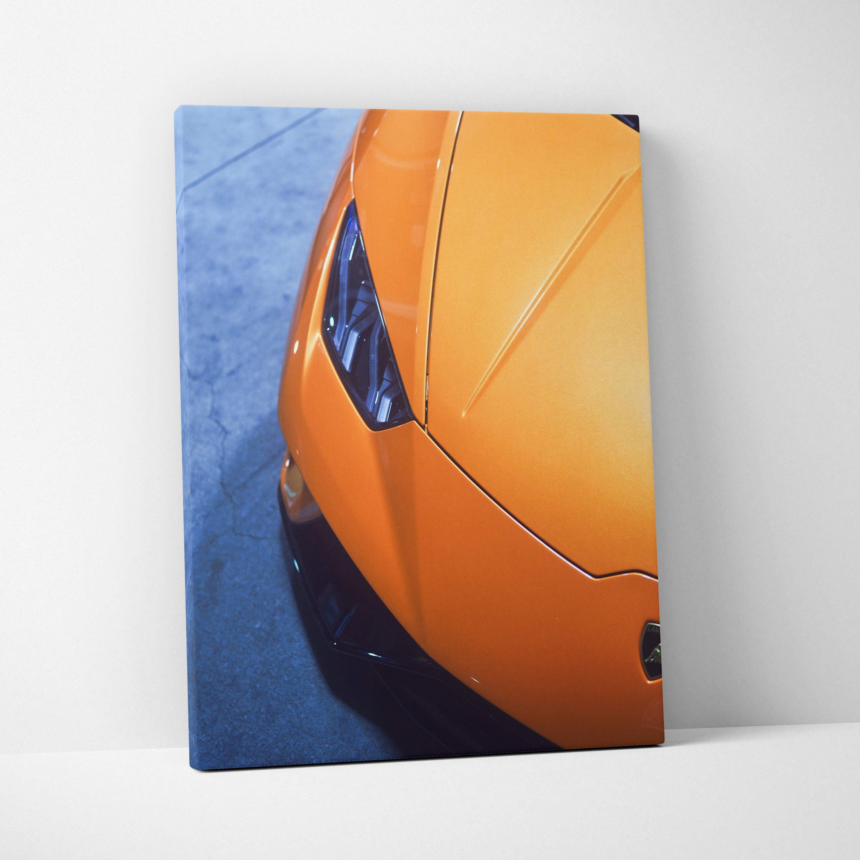 Orange Lamborghini front detail on vertical canvas wall art with blue background.
