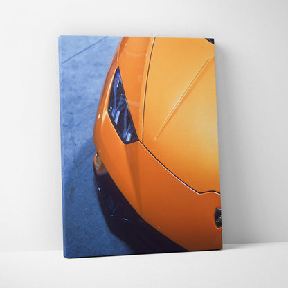 Orange Lamborghini front detail on vertical canvas wall art with blue background.
