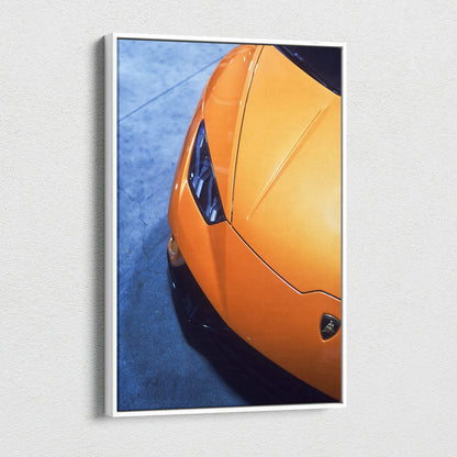 Orange Lamborghini Huracan close-up canvas art with sleek lines and sharp headlights on blue background wall art.