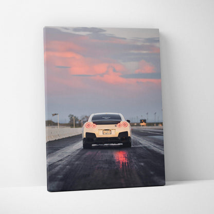 Nissan R35 GTR on wet road at sunset vertical canvas wall art with vibrant sky colors.
