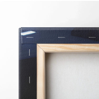Close-up of wooden stretcher frame on black canvas wall art with visible staples and texture.
