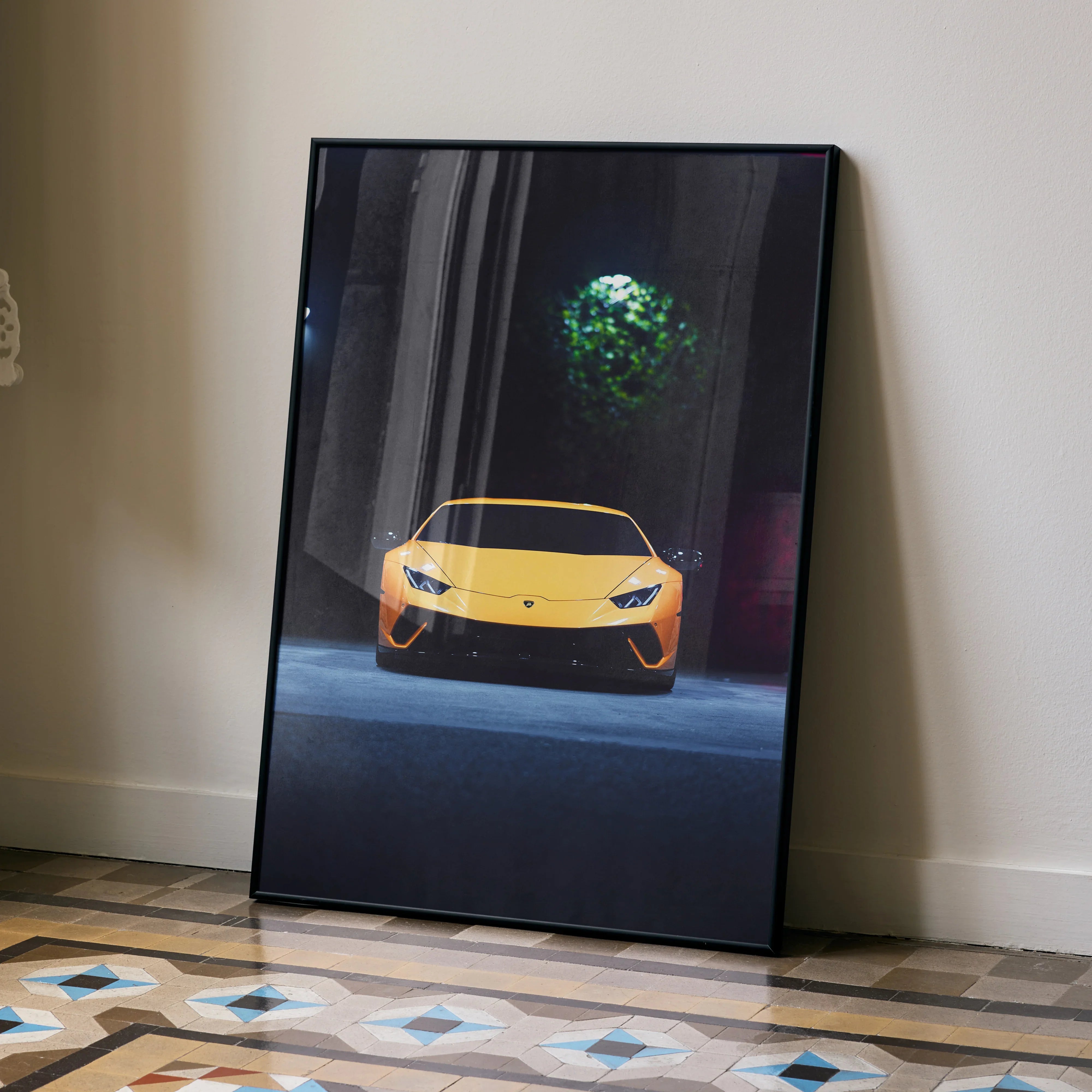 Yellow Lamborghini Huracan front view poster leaning against wall with geometric tiled floor wall art.
