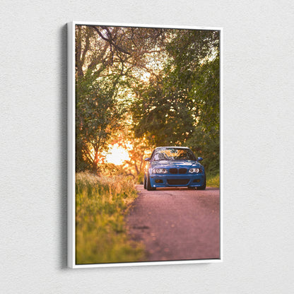 BMW E46 M3 blue car at sunset on vertical canvas wall art with forest background.