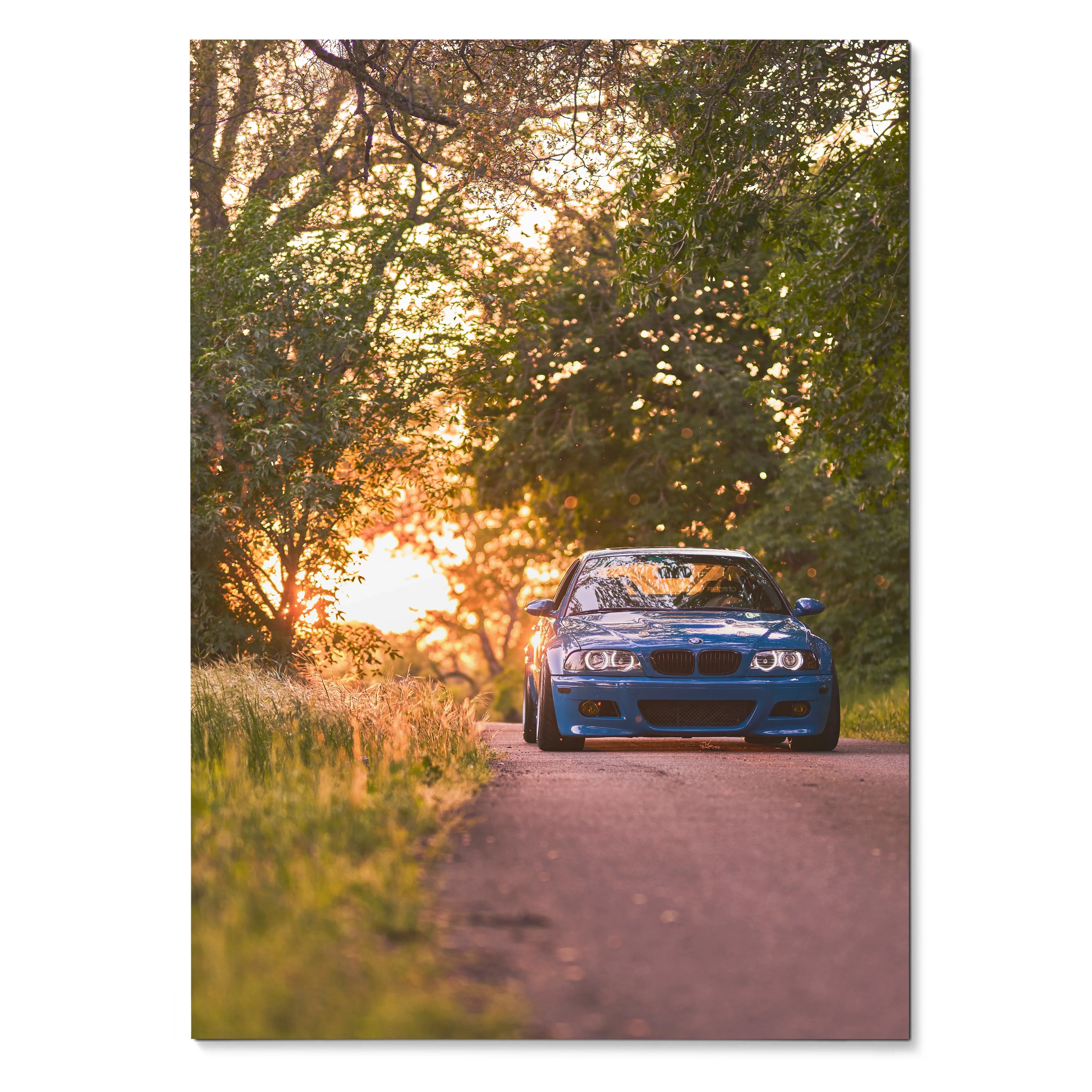 BMW E46 M3 parked on sunset road surrounded by trees poster wall art.