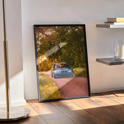 BMW E46 M3 poster in black frame leaning on wall, automotive wall art with autumn trees background.