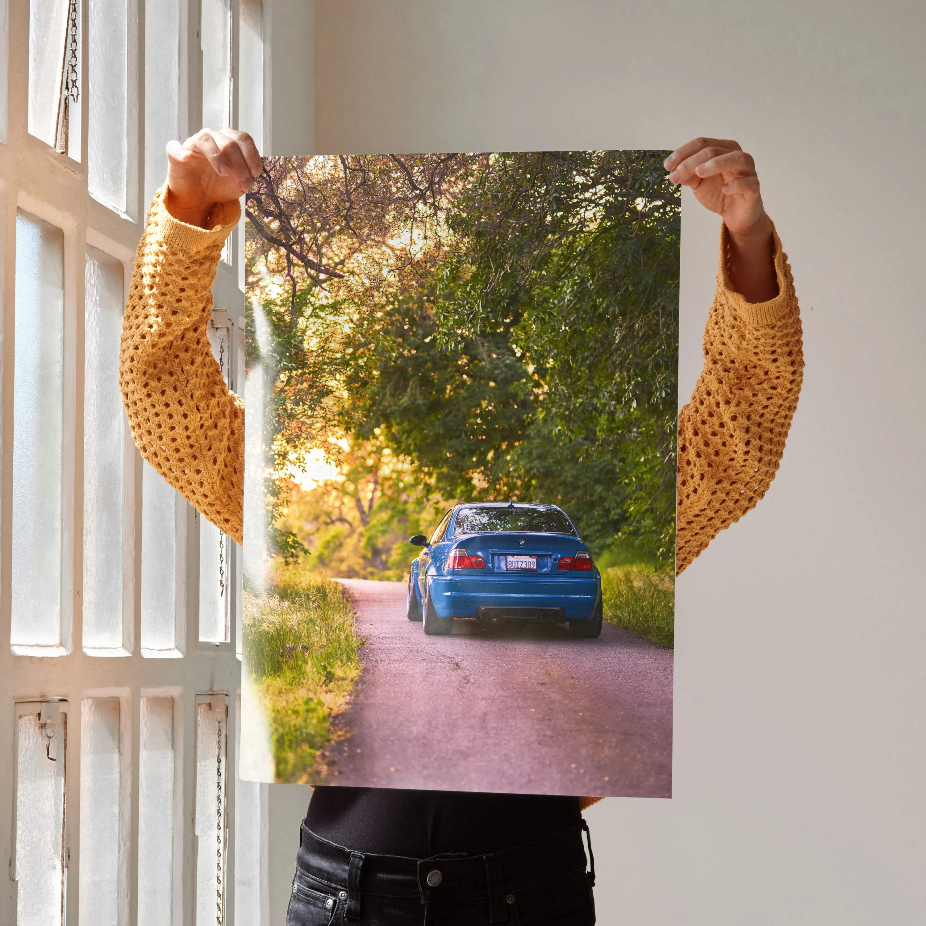 BMW E46 M3 driving on a forest road at sunset poster wall art with vibrant colors.