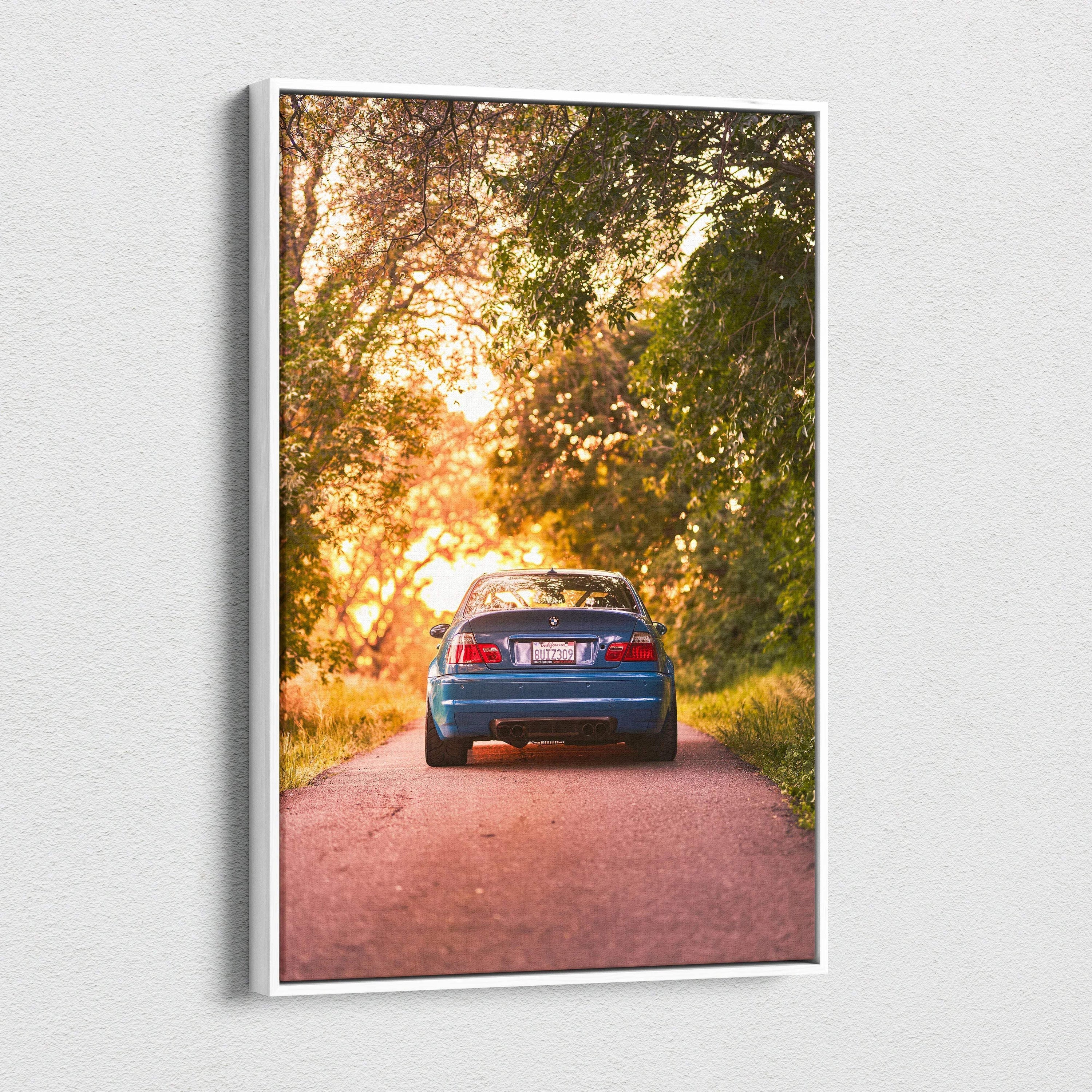 BMW E46 M3 blue car canvas wall art with sunset and tree-lined road in vertical format.