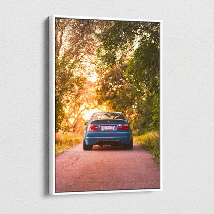 BMW E46 M3 blue car canvas wall art with sunset and tree-lined road in vertical format.