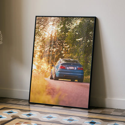 BMW E46 M3 poster wall art with sunset and forest road scene in warm golden light.